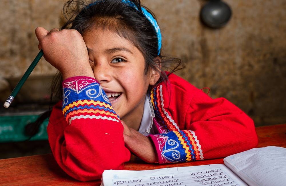 Jente fra Peru på skolebenken. Vi jobber med å sikre barn og unge en trygg og god utdanning.