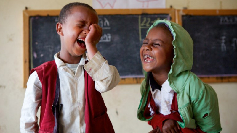 To barn som ler, foran tavle
