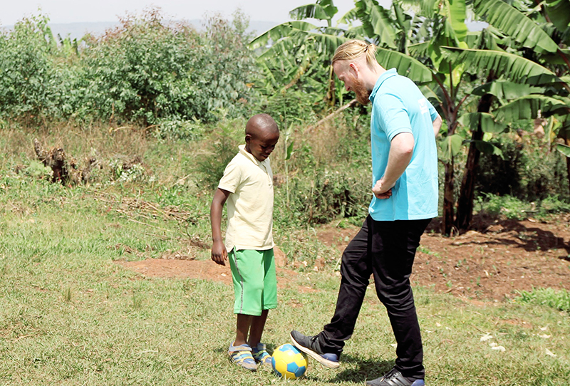 En mann og en liten gutt spiller fotball
