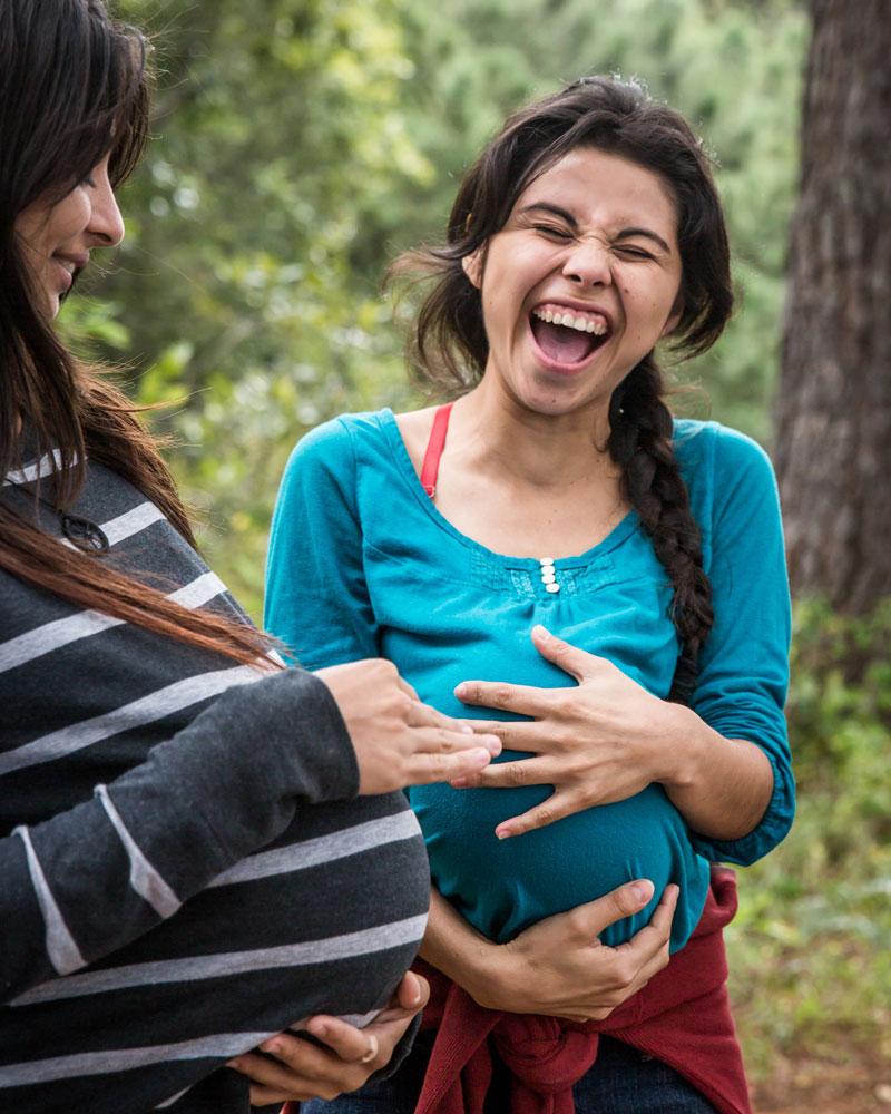 To jenter med ballong under genseren for å illudere graviditet
