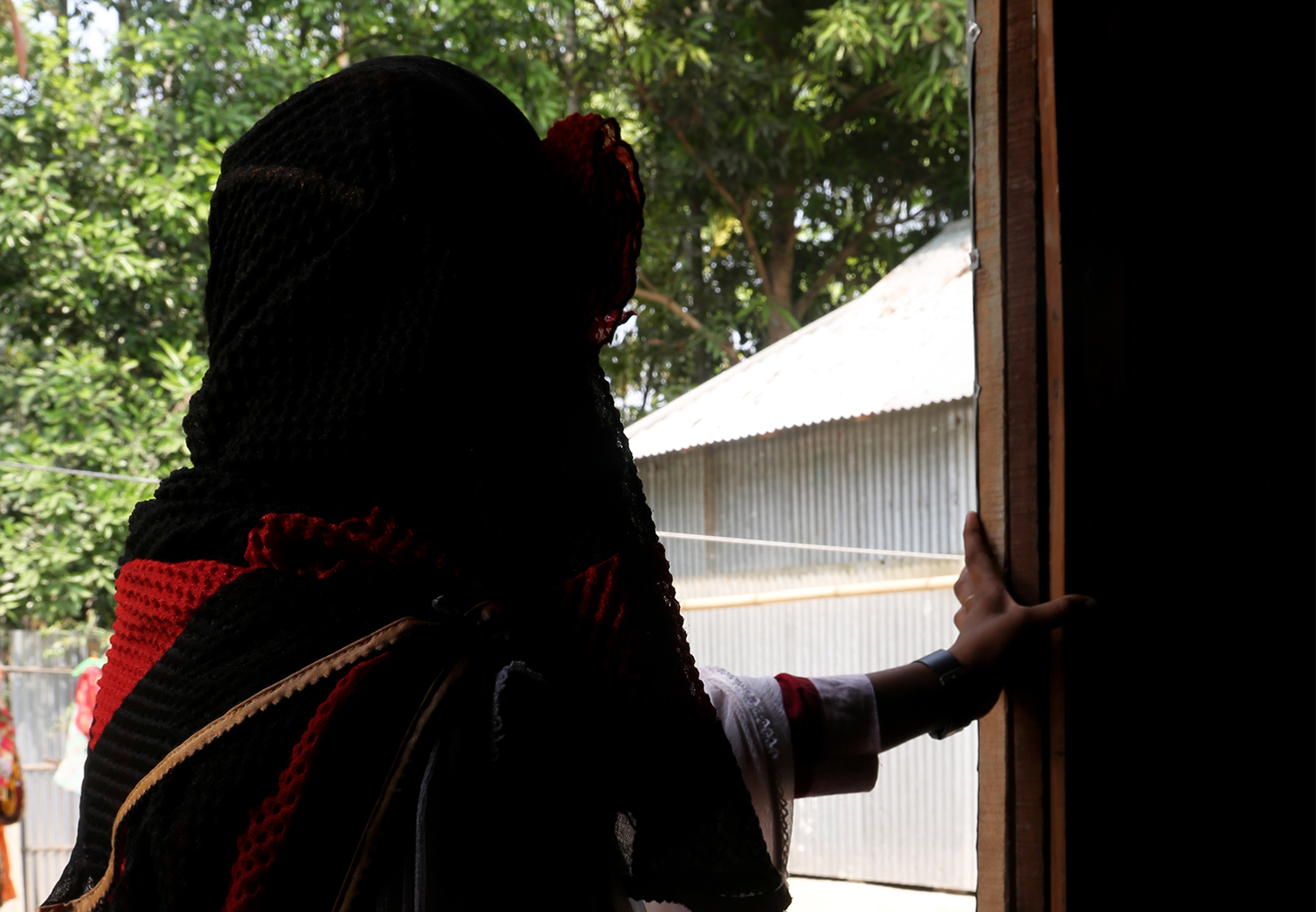 Roxana fra Bangladesh står å ser ut igjennom døra. Hun unnslapp barneekteskap.