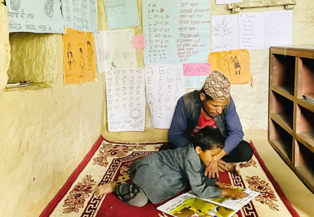Gutt fra Nepal som leser på ett av lesesenterne som er støttet av Plans juleprosjekt.