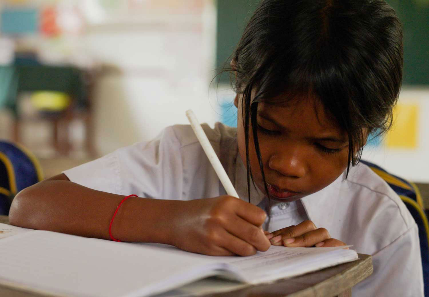 Khnhung fra Kambodsja gjør skolearbeid.