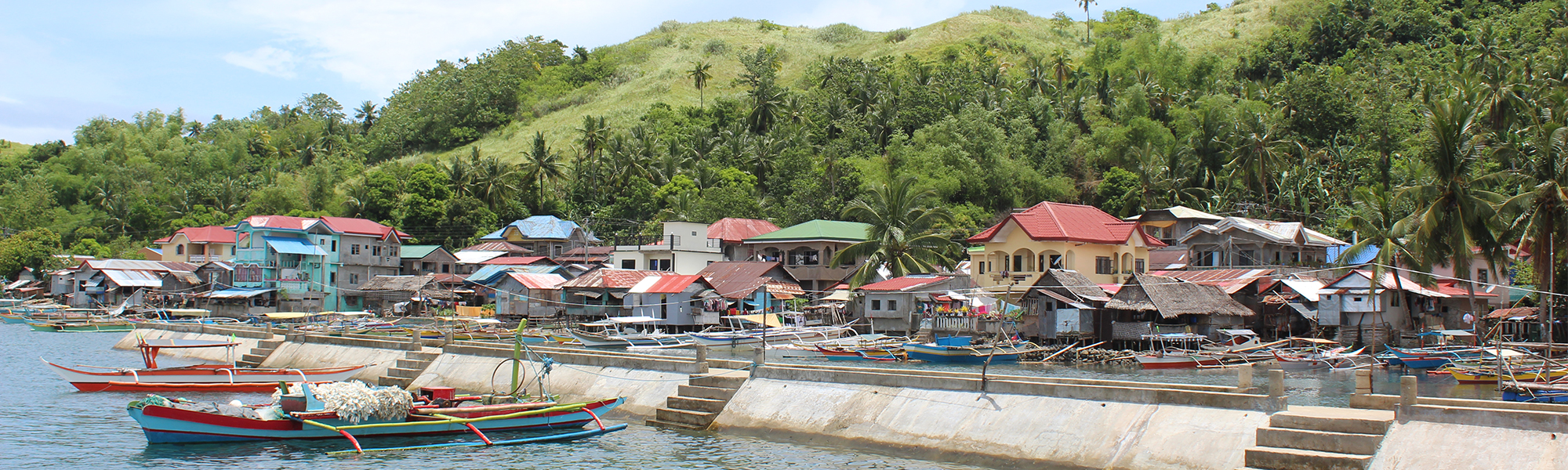 Båter med brygge og hus i bakgrunnen i Øst-Samar, Filippinene