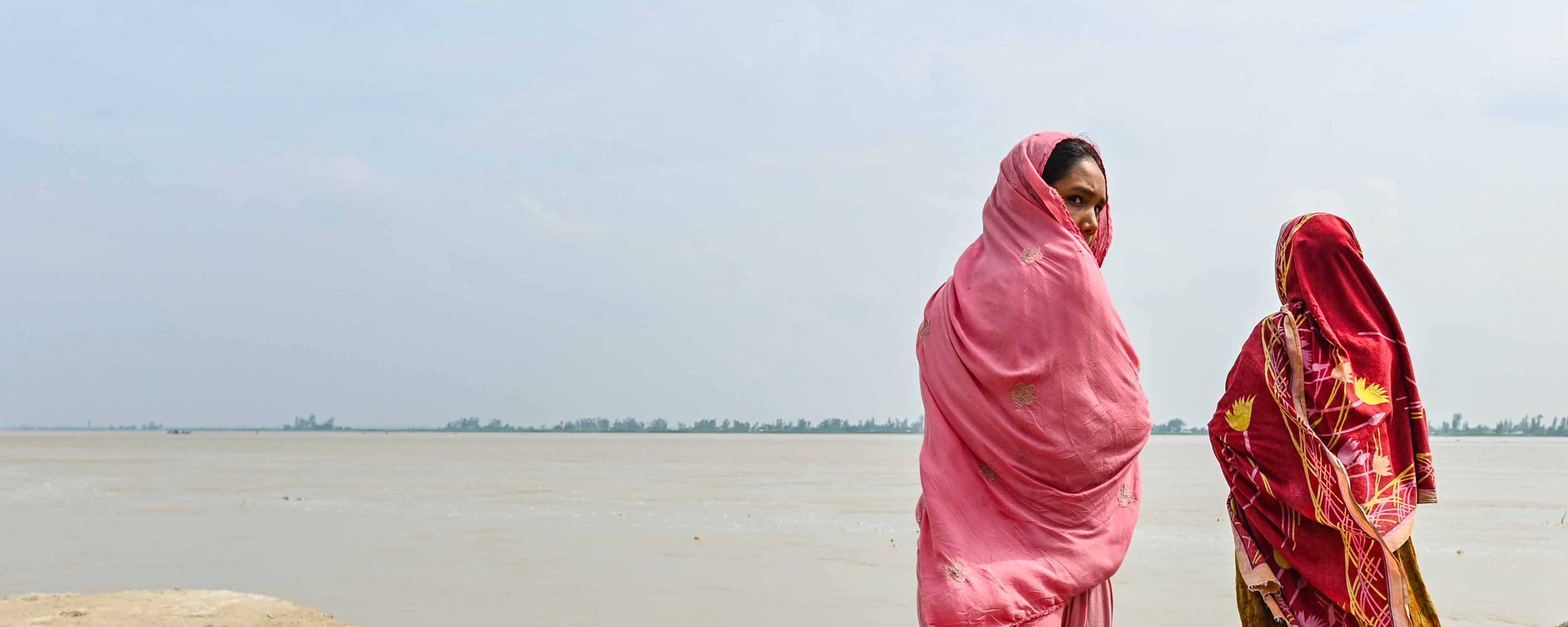 Mor og datter står ved havet i Bangladesh