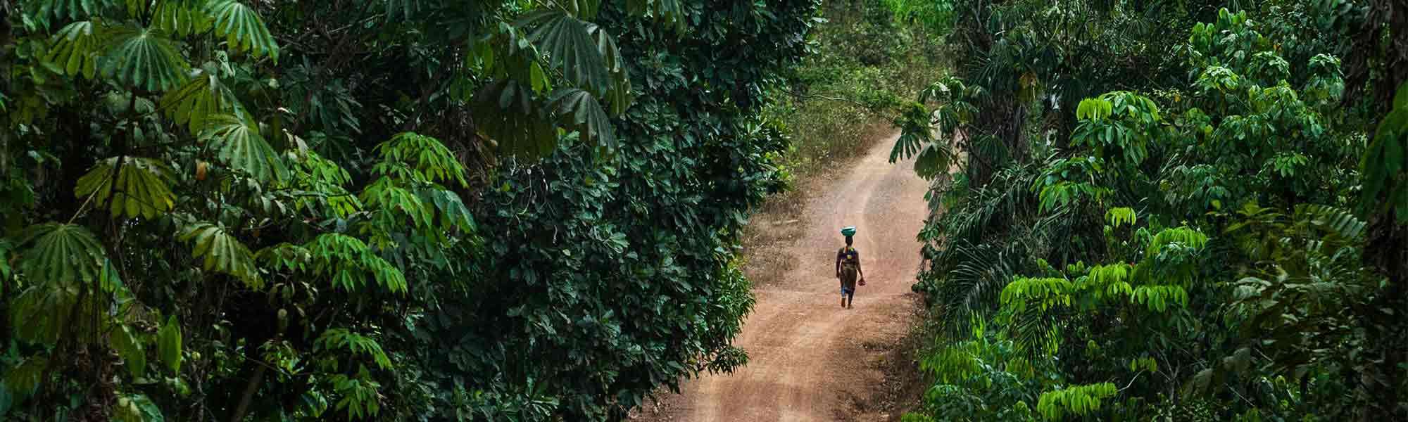 Kvinne på en øde vei i en skog i Liberia