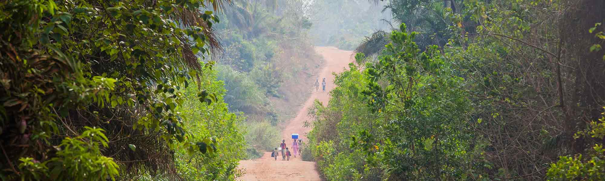 Mennesker på vei i grønnt landskap i Guinea