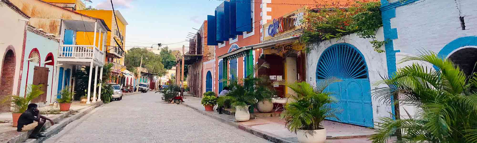 Gate med fargerike hus i byen Jacmel i Haiti