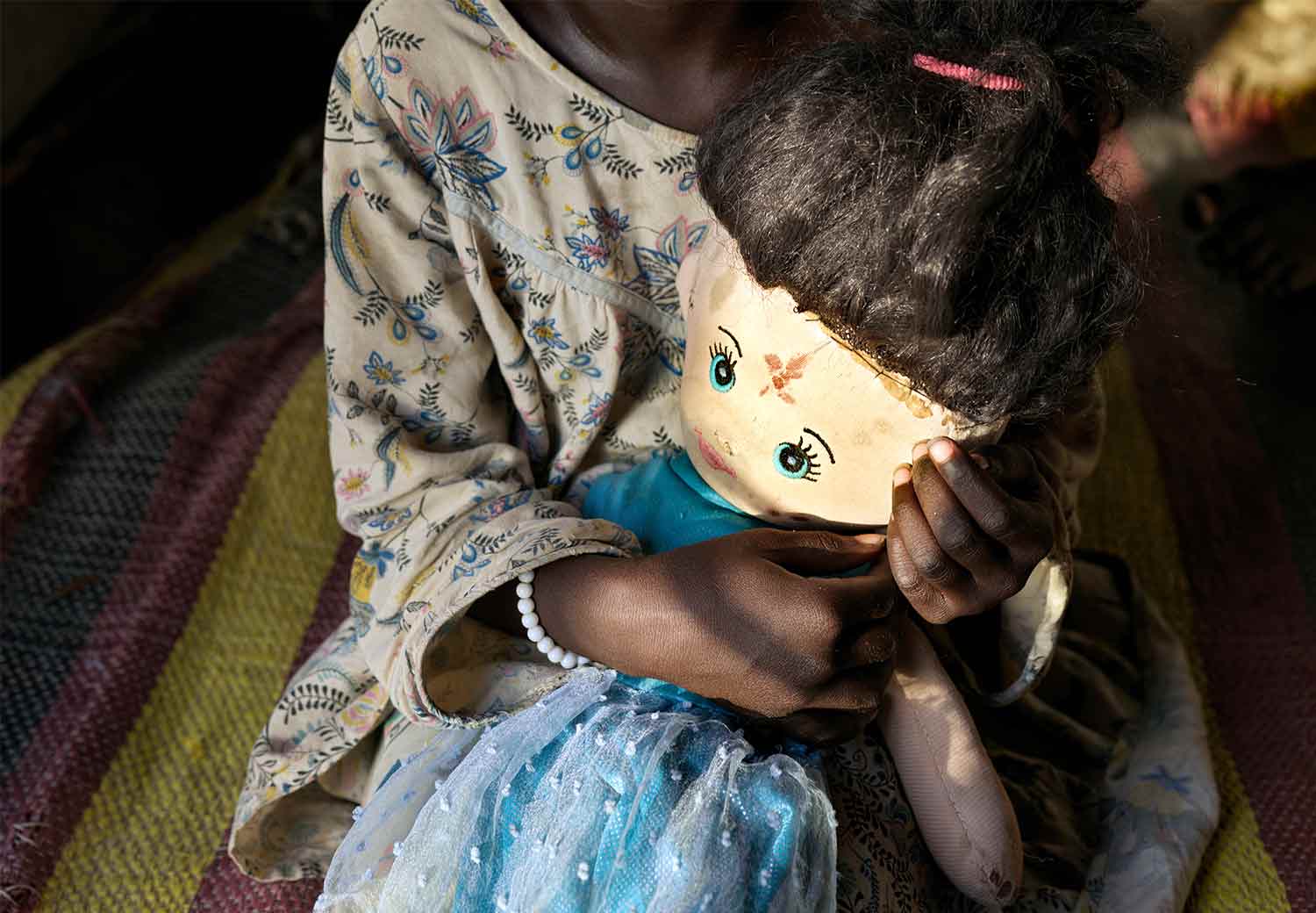 Samiras søster på fem år. Hun holder tett på dukken sin.