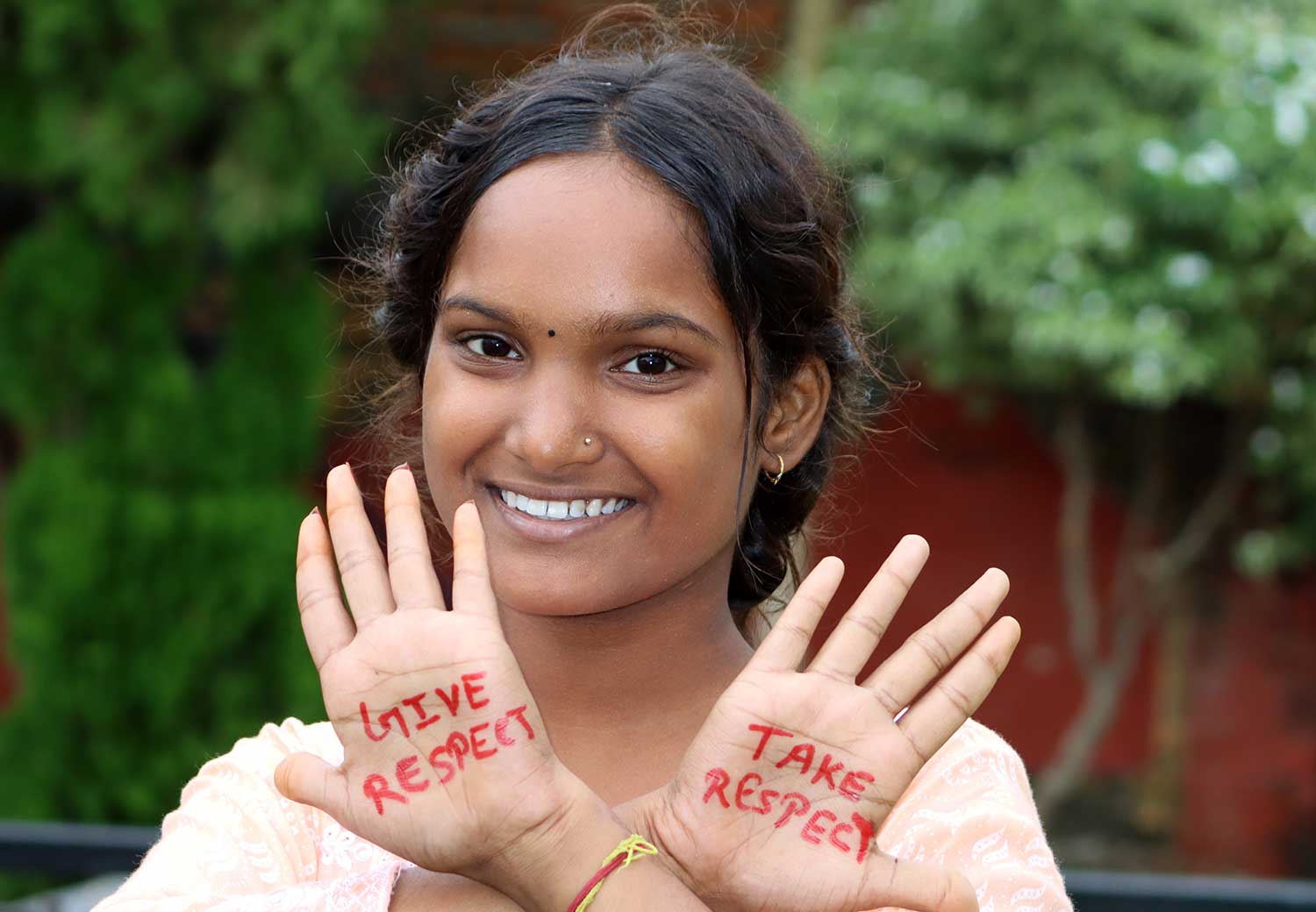 Jente med skrift på hendene: Give respect, take respect.