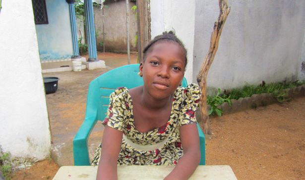 Jente skriver og ser inn i kameraet i Kamerun