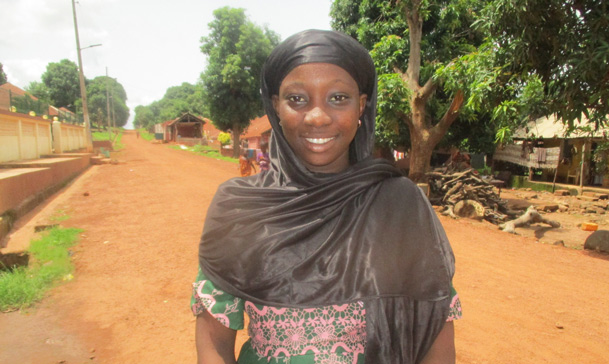 Jente smiler mot kamera på landsbygden i Guinea Bissau