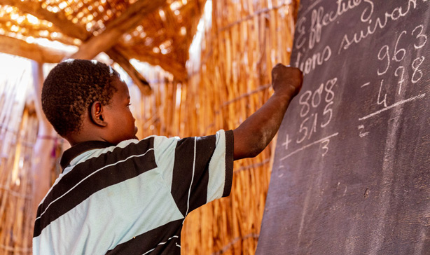 Gutt i Niger skriver på tavle i skolen