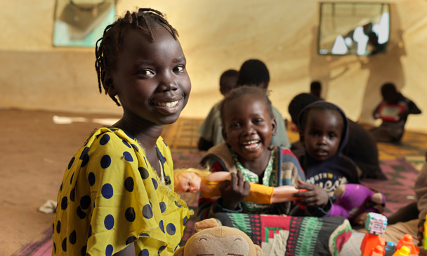 Jente smiler mot kamera i klasserom i Sør-Sudan