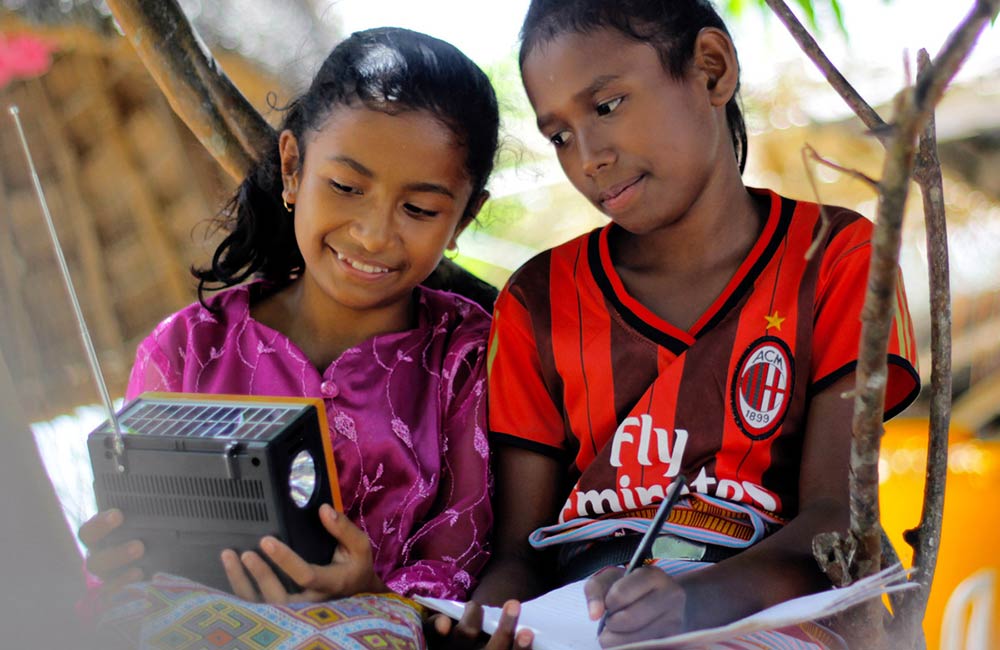 Barn fra Indonesia følger undervisningen via radio.