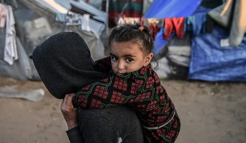 Jente bæres på ryggen av et søsken i Gaza.