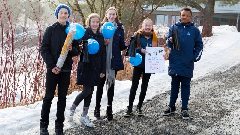 Elever fra Ramberg skole med selger kaffe og holder ballonger med Planlogo