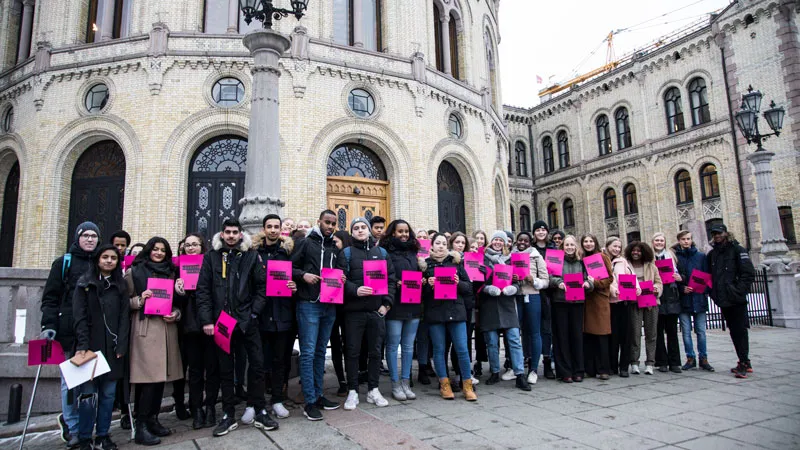 Unge norske Wedding Busters utenfor Stortinget, med rosa plakater