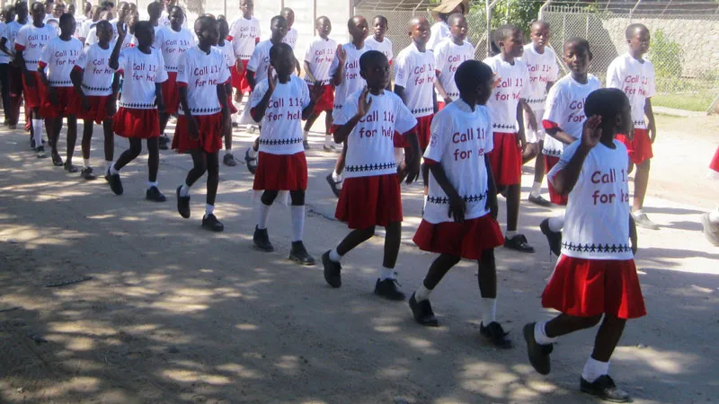 Barn med t-trøyer hvor det står "Call 116 for helt" feirer åpning av childline-senter i Zimbabwe