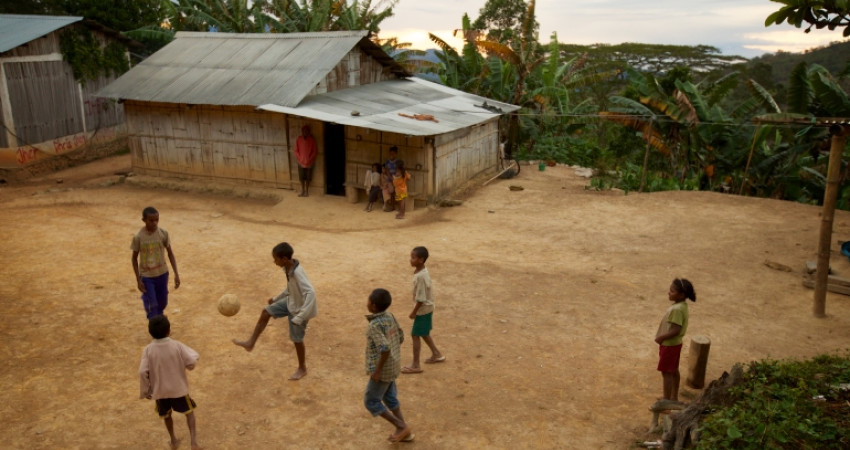 gutter spiller fotball utenfor et hus