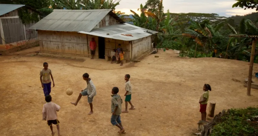 gutter spiller fotball utenfor et hus