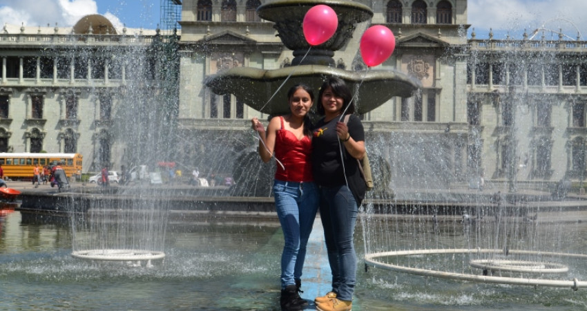 To jenter står foran en fontene