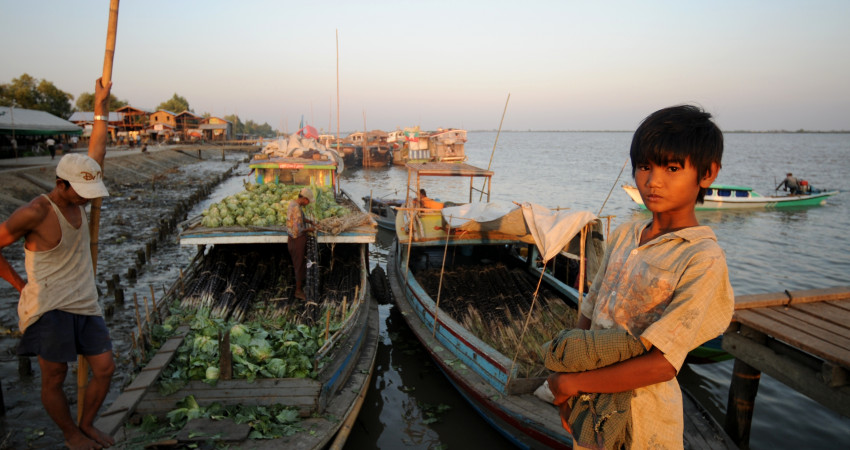 En mann selger grønnsaker fra en båt