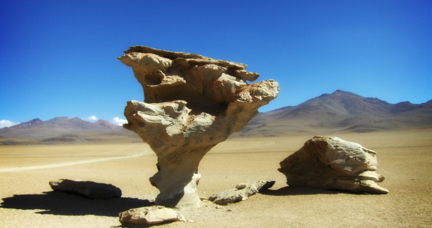 en soppformet stein stikker opp i et øde ørkenlandskap