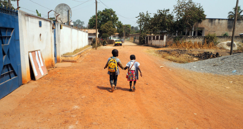 To barn går til skolen hånd i hånd