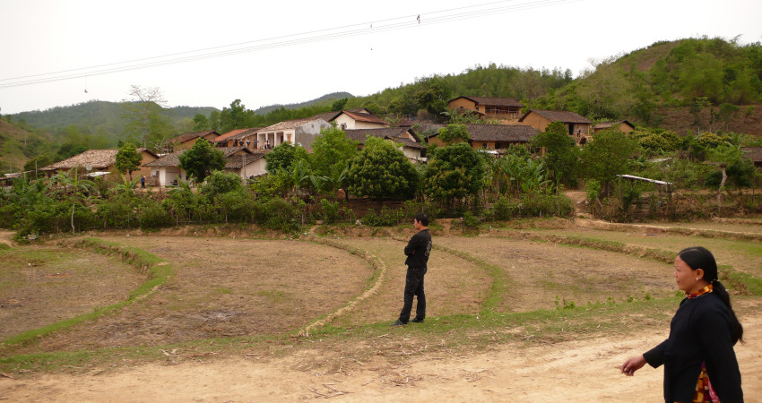 En kvinne går på en vei forbi en liten landsby i Bac Giang