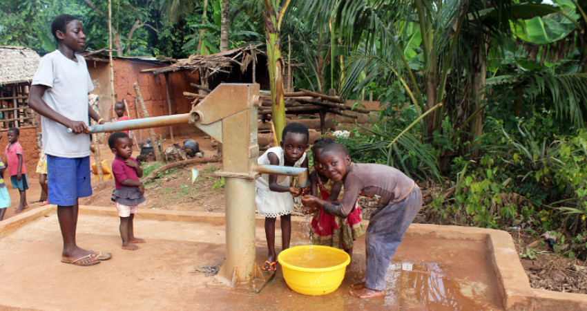 Barn henter vann fra vannpumpe