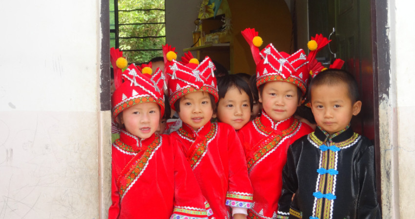 Fem skoleelever med tradisjonell drakt fra Guangnan-regionen