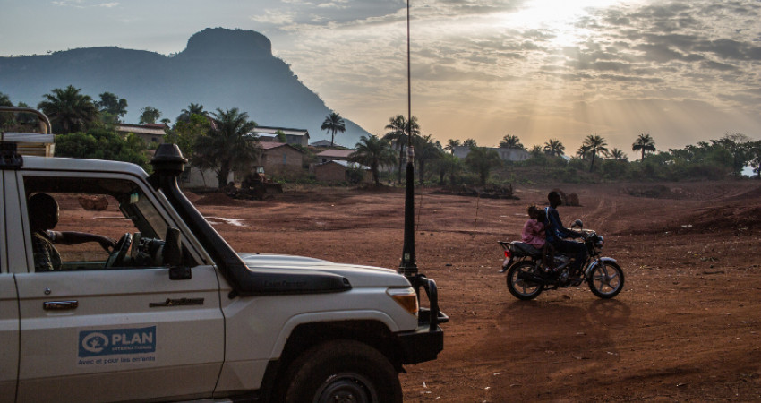 Bil og moped kjører i vakkert landskap i Guinea
