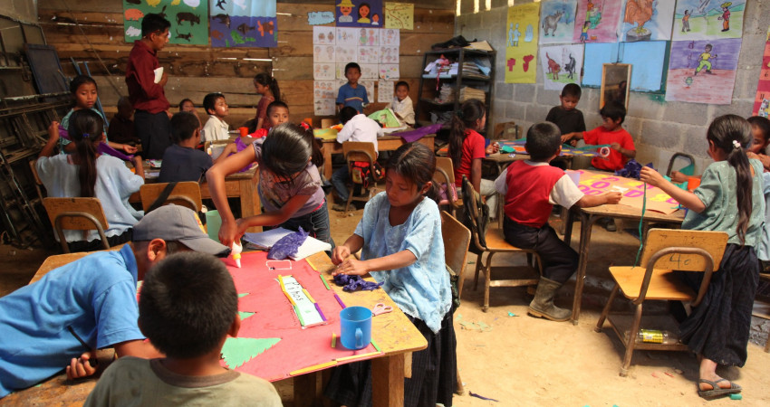 Mange barn i et klasserom jobber med kreative oppgaver