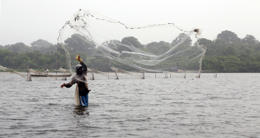 En mann fisker med garn i Lake Togo
