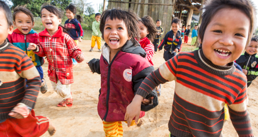 Barn løper smilende mot kamera under lek