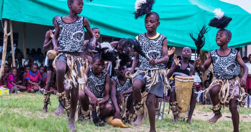Tre jenter danser i tradisjonell drakt