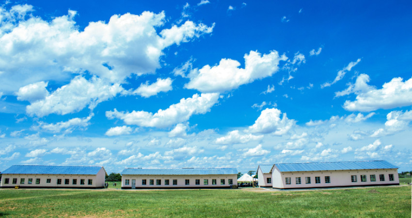 Fire, nye skolebygg i solskinn og blå himmel