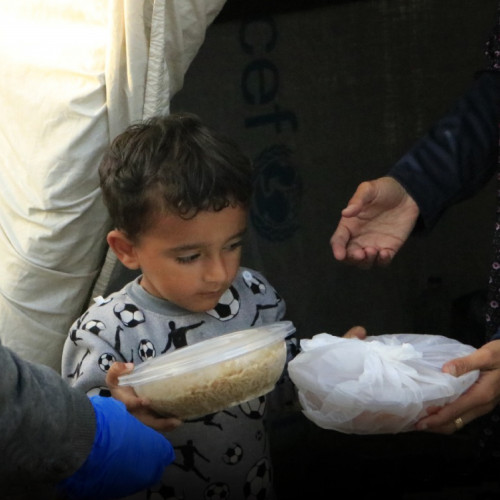 En ung gutt får utdelt mat i Gaza
