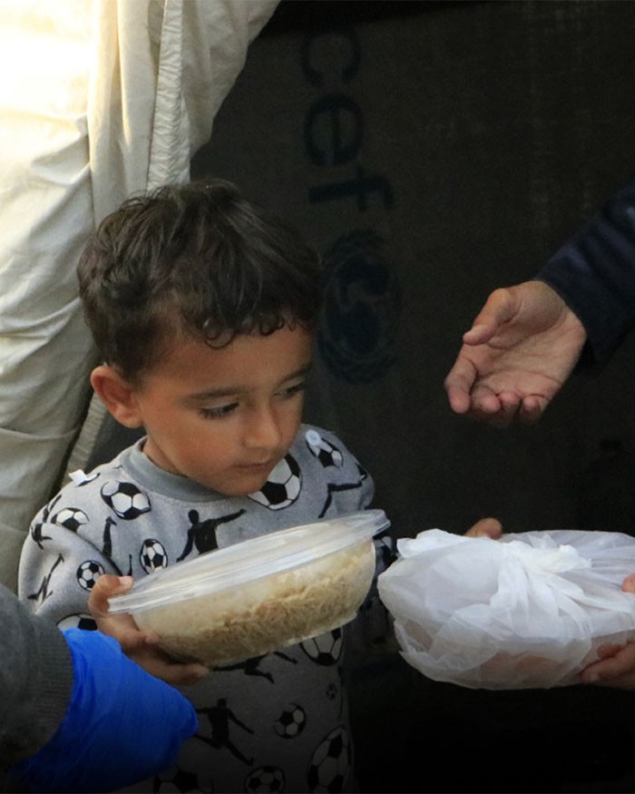 En ung gutt får utdelt mat i Gaza