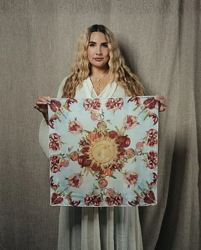 Thea Elise Klingvall viser frem skjerfet hun har designet.