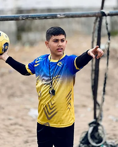 Gutt spiller fotball i ruinene i Gaza
