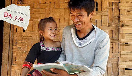 Far og datter leser bok i Laos
