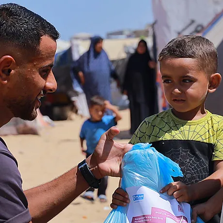 Hjelpearbeider gir mat til barn i Gaza