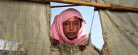 Tenåringsjente med skaut ser alvorlig i kamera