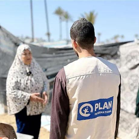 Mann med Plan-vest møter sivil dame i leir