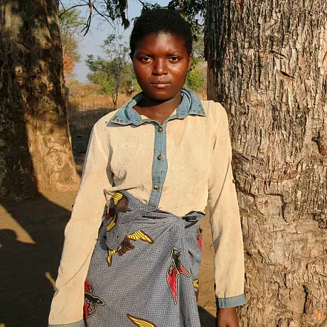 Jente lener seg mot et tre i Zambia