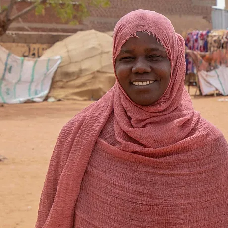 Smilende mottaker av Plans nødhjelp i Sudan