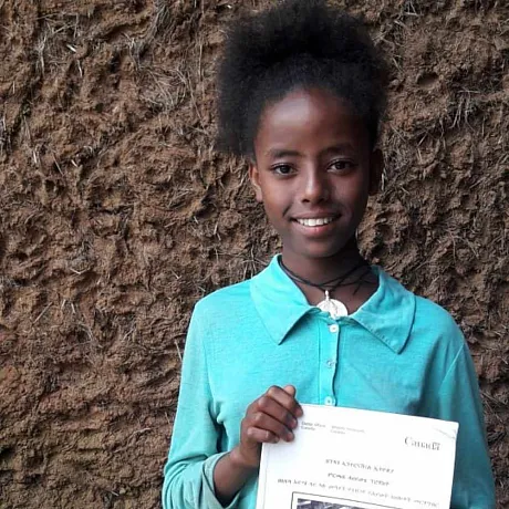 Meskerem fra Etiopia holder i et skolediplom.