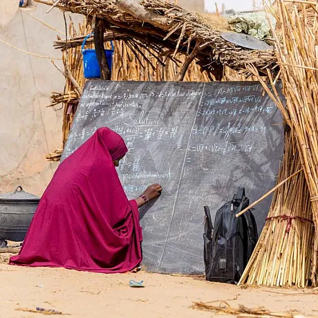 Kvinne skriver på tavla i Niger